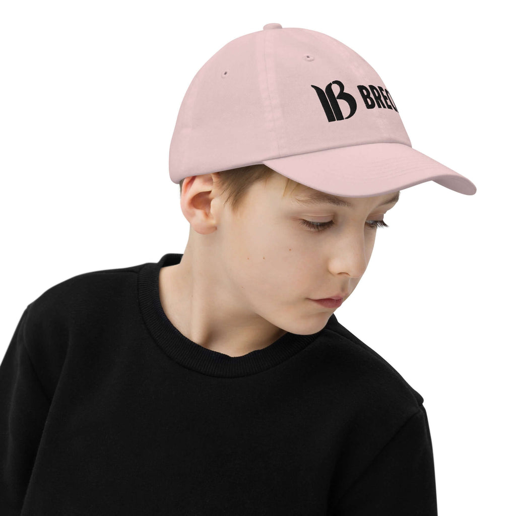 Breckenridge Youth Baseball Cap in pink worn by a child showcasing Mtns Co Trail Map Logo. Official licensed ski resort apparel.