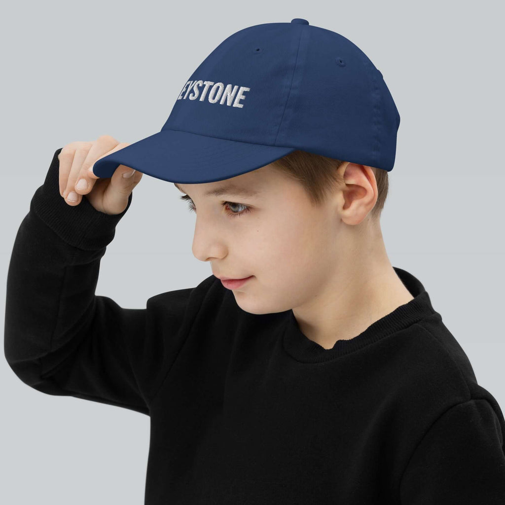 Keystone Youth Baseball Cap on boy, showcasing Mtns Co Trail Map Logo, perfect for official licensed ski resort apparel.