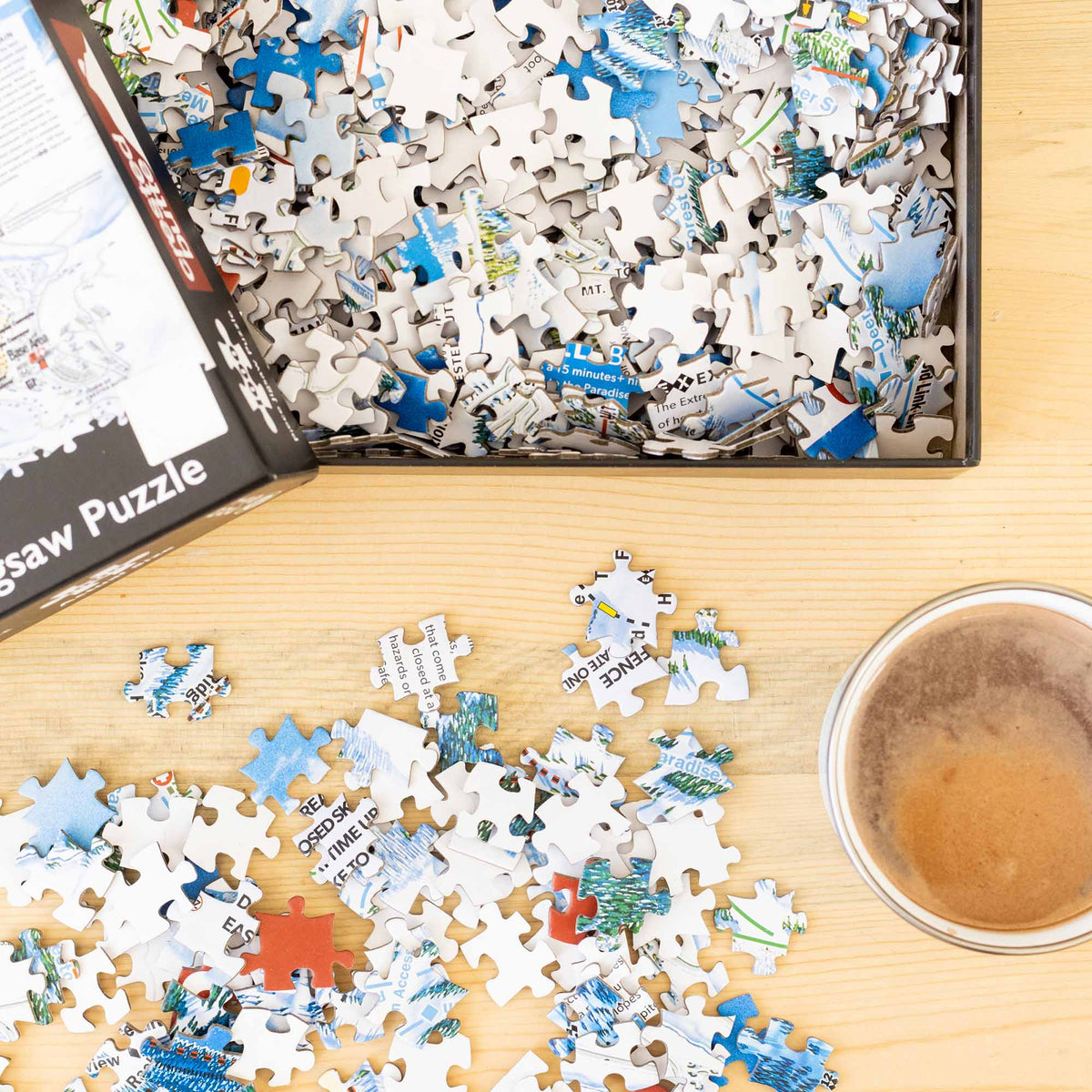 Crested Butte Ski Resort Jigsaw Puzzle – 1000 Pieces pieces scattered on table from Mtns Co Puzzle box.