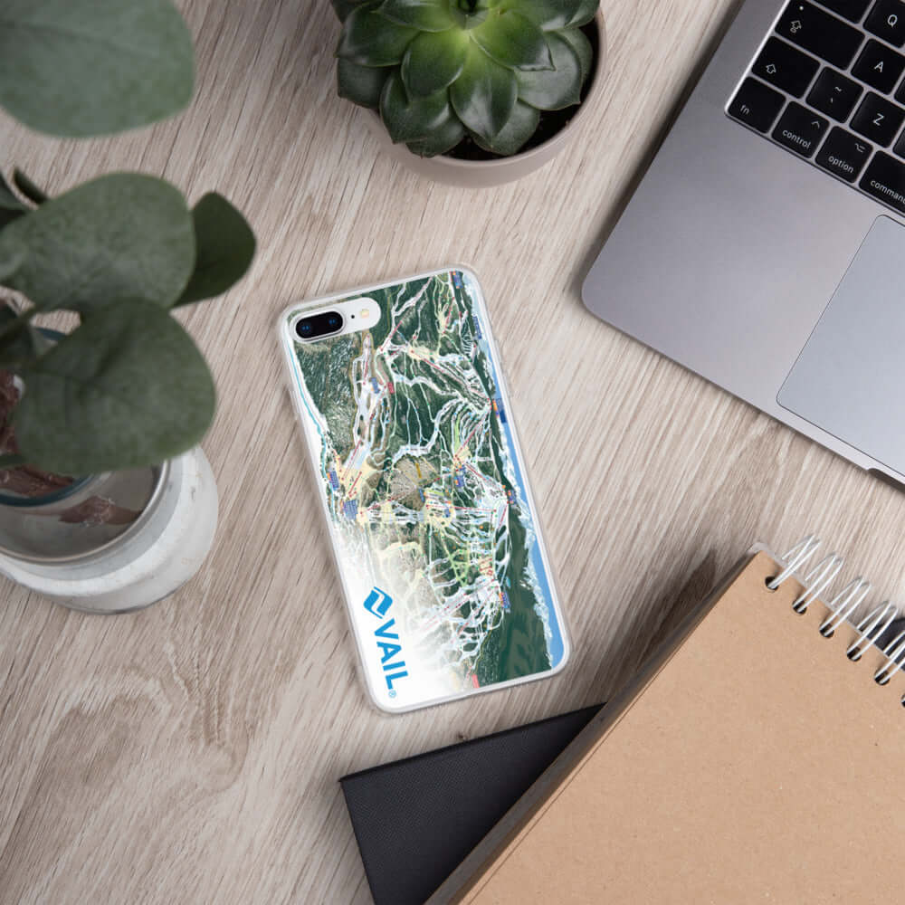 Vail Trail Map iPhone Case with Mtns Co logo on a wooden desk, showcasing its sleek design and ski resort map